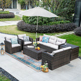 Outdoor patio furniture set with cushions and an umbrella on a patio.