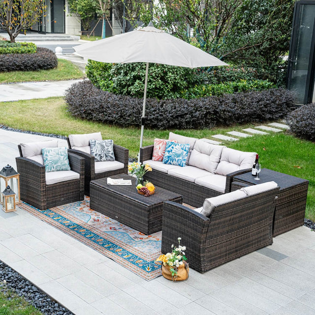 Outdoor patio furniture set with cushions and an umbrella on a patio.